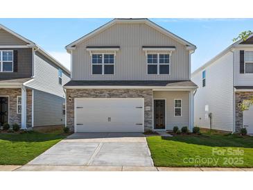 Charming two-story home featuring a stone accent facade, attached garage, and well-manicured front lawn at 2124 Clapham Ct, Charlotte, NC 28215