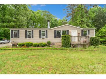 Charming home featuring a well-maintained lawn, mature trees, and inviting front porch at 5128 Green Leaf Ct, Mount Holly, NC 28120