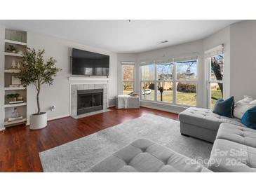 Bright living room featuring a fireplace, hardwood floors, and plenty of natural light at 529 N Graham St # 2G, Charlotte, NC 28202