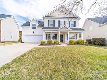 Charming two-story home featuring a welcoming front porch and well-maintained landscaping at 9684 Ravenscroft Nw Ln, Concord, NC 28027