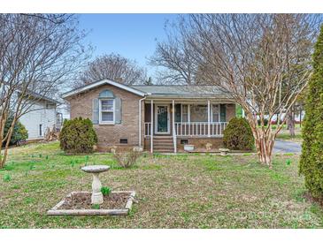 Charming brick home with landscaped front yard and a quaint covered porch entrance at 12 Roberta Rd, Concord, NC 28027