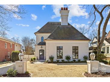 An elegant, light-colored stone home with a slate roof, and a well-manicured gravel front yard and gate at 1414 Biltmore Dr, Charlotte, NC 28207