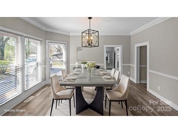 This dining room features a modern chandelier and a large window with great lighting and stylish decor at 220 W Bell St, Statesville, NC 28677