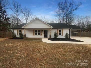 Charming single-story home featuring white siding, a black roof, a welcoming porch, and a convenient carport at 3792 Rolling View Ln, Maiden, NC 28650