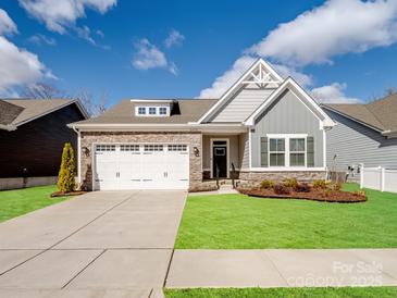 Charming single-Gathering home featuring stone accents, a two-car garage, and a well-manicured lawn at 6420 Cambridge Dr, Harrisburg, NC 28075