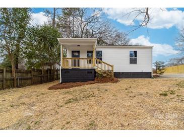 Charming single-story home featuring a covered porch with wood stairs and black painted foundation at 813 Carrid Dr, Gastonia, NC 28052