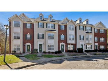 Charming townhome showcasing brick accents, green shutters, and well-maintained landscaping at 10094 Treeside Ln, Matthews, NC 28105