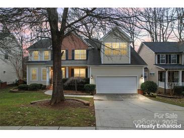 Charming two-story home with a two-car garage, manicured lawn, and mature trees at 1017 Anduin Falls Dr, Charlotte, NC 28269