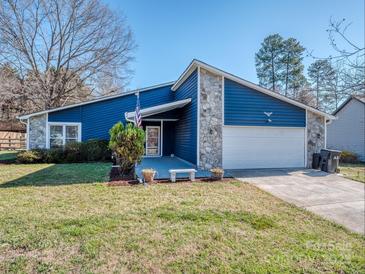 Charming blue home with stone accents, an American flag, and a cozy front bench at 11014 Fox Mill Ln, Charlotte, NC 28277