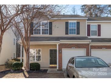 Charming townhome featuring a brick-accented facade, attached garage, and manicured landscaping at 13923 Singleleaf Ln, Charlotte, NC 28278