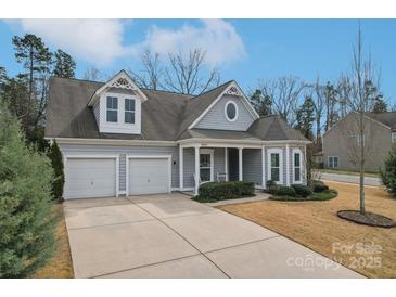 Charming home featuring a two-car garage, beautifully landscaped front yard, and inviting covered porch at 14621 Brannock Hills Dr, Charlotte, NC 28278