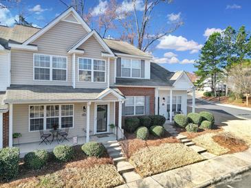 Attractive two-story townhome features a well-maintained lawn and inviting front porch with seating at 1559 Maypine Commons Way, Rock Hill, SC 29732