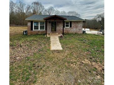 Charming single-story brick home with covered porch, set on a spacious lot with mature trees and a basketball court at 1640 Old Friendship Rd, Rock Hill, SC 29730