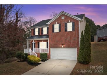 Charming two-story brick home with a well-manicured lawn and attached two-car garage at 302 Flanders Dr, Mooresville, NC 28117