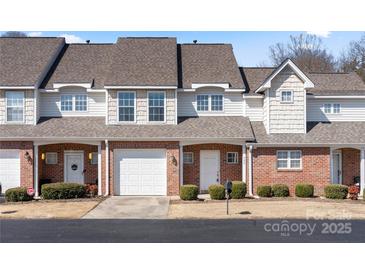 Charming townhome with brick facade, white accents, and well-maintained landscaping at 304 Valley Brook Se Ln, Concord, NC 28025