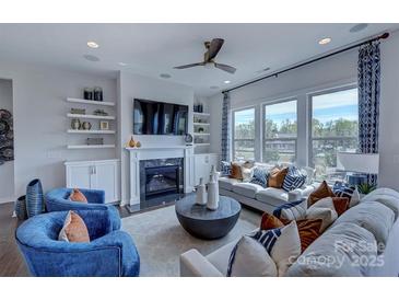 Bright living room with fireplace, built-in shelves, large windows and stylish blue accents at 316 Basil Dr, Indian Trail, NC 28079