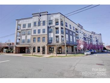 Modern condo building with a combination of brick and siding, as well as beautiful flowering trees at 3630 N Davidson St, Charlotte, NC 28205