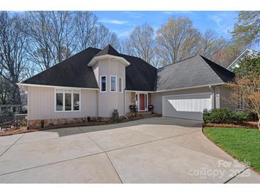 Inviting home with a paved driveway, two-car garage, and stone accents under windows at 420 Medearis Dr, Charlotte, NC 28211