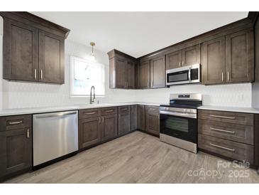 Updated kitchen featuring stainless steel appliances, granite counters and dark wood cabinets at 430 Stoneycreek Ln, Rock Hill, SC 29730