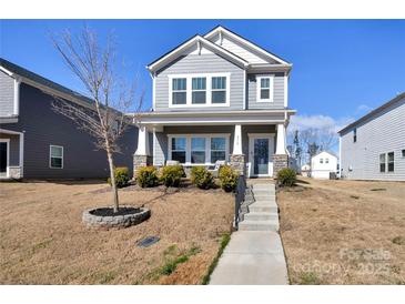 Charming two-story home featuring a welcoming front porch with stone accents and manicured landscaping at 514 Nixon Rd, Belmont, NC 28012