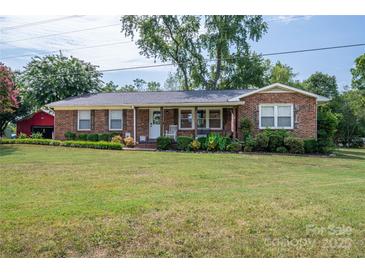 Charming brick ranch home with a well-manicured lawn, mature trees, and an inviting front porch at 7271 Hallman Mill Rd, Vale, NC 28168