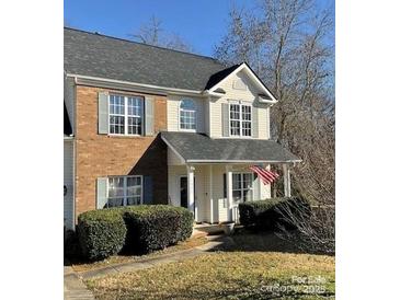 Charming two-story townhome with brick accents, manicured bushes, and a welcoming front porch at 1941 Olsen Ln, Charlotte, NC 28213