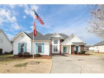 Charming two-story home with blue shutters, well-manicured landscaping, and an inviting entrance with American flag at 2003 Hemby Commons Pkwy, Indian Trail, NC 28079