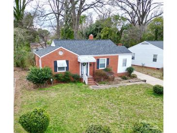 Charming brick home featuring a well-maintained lawn and manicured shrubs, exuding classic curb appeal at 2414 Belfast Dr, Charlotte, NC 28208