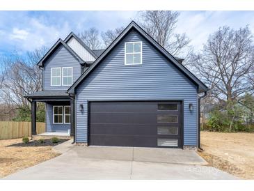 Charming two-story home with blue siding and a modern black garage door at 324 Cabarrus W Ave, Concord, NC 28025