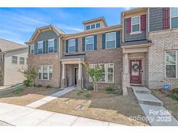 Charming two-story townhome featuring a brick facade and stylish architectural details at 5341 Orchid Bloom Dr # 55, Fort Mill, SC 29707