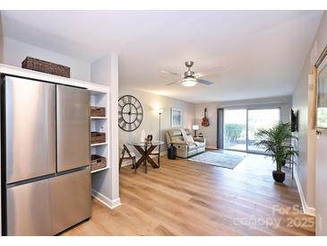 Bright living area with wood floors, modern fan, and access to outdoor space at 7101 Quail Meadow Ln, Charlotte, NC 28210