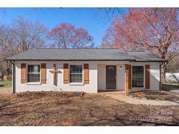 Charming, remodeled single-story home featuring brick facade, wooden shutters, and a well-manicured front yard at 8009 Idlewild Rd, Indian Trail, NC 28079