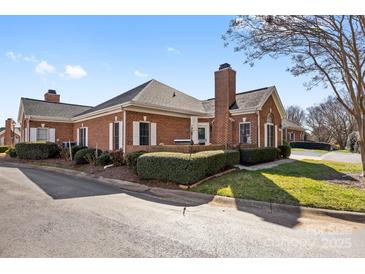 Charming brick home featuring manicured landscaping, a cozy patio, and a classic chimney at 8328 Highland Glen Dr, Charlotte, NC 28269