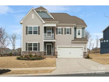 Charming two-story home featuring a welcoming porch, two-car garage, and manicured front yard at 925 Deep River Way, Waxhaw, NC 28173