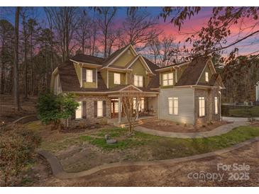 Charming two-story home with stone and siding, complemented by a meticulously landscaped front yard at 109 Hawksnest Ln, Mooresville, NC 28117