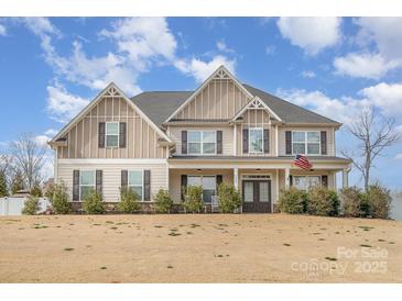 Charming two-story home with stylish design elements and a well-manicured lawn under a beautiful blue sky at 2605 Lakefront Dr, Belmont, NC 28012