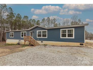 Inviting single-story home with blue siding, a wooden porch, and large windows at 2647 Dusty Trail Ln, Lancaster, SC 29720