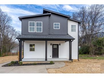 Charming two-story home featuring a covered porch and modern black and white exterior at 320 Cabarrus W Ave, Concord, NC 28025