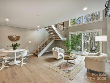 Open living area with staircase, accent rug, balcony and natural light for a cozy feel at 3504 Colony Rd # R, Charlotte, NC 28211