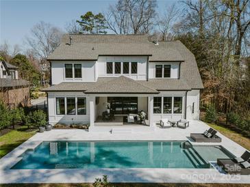 Stunning backyard featuring a sparkling pool, cozy patio, and lush landscaping of this two-story home at 5608 Closeburn Rd, Charlotte, NC 28210