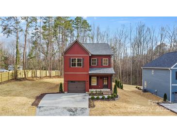 Charming two-story home with a well-manicured front yard and a one-car garage at 607 W Stanly St, Stanfield, NC 28163