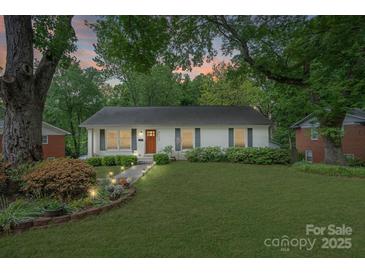 Charming single-story home featuring a well-manicured lawn, inviting walkway, and beautifully landscaped flowerbeds at 6126 Netherwood Dr, Charlotte, NC 28210