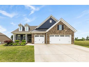 Charming brick home with a three-car garage, black shutters and a beautifully maintained lawn at 1300 Dali Blvd, Mount Holly, NC 28120