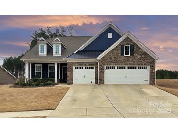 Charming brick home featuring a two-car garage, and a manicured front yard at 1300 Dali Blvd, Mount Holly, NC 28120