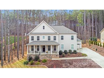 Charming two-story home with a welcoming front porch and beautifully landscaped yard at 220 Kenway Loop, Mooresville, NC 28117