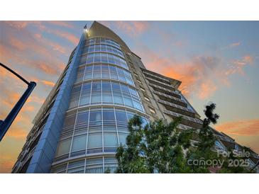 Modern high-rise building featuring expansive glass windows against a colorful sky at 505 E 6Th St # 804, Charlotte, NC 28202