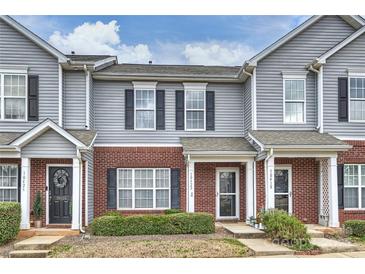 A charming townhouse with a brick and gray siding exterior and well-maintained landscaping at 10422 Stokeshill Ct, Pineville, NC 28134