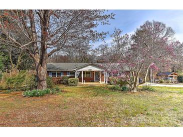 Charming brick home featuring a well-maintained lawn and a cozy front porch at 1235 Robinhood Cir, Charlotte, NC 28227