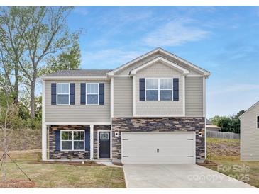 Charming two-story home featuring stone accents, gray siding, a two-car garage, and a well-maintained lawn at 124 Rustling Waters Dr, Mooresville, NC 28117