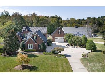 Expansive brick home with a lush lawn, oversized driveway, detached garage and additional parking space at 3099 Trinity Church Rd, Concord, NC 28027